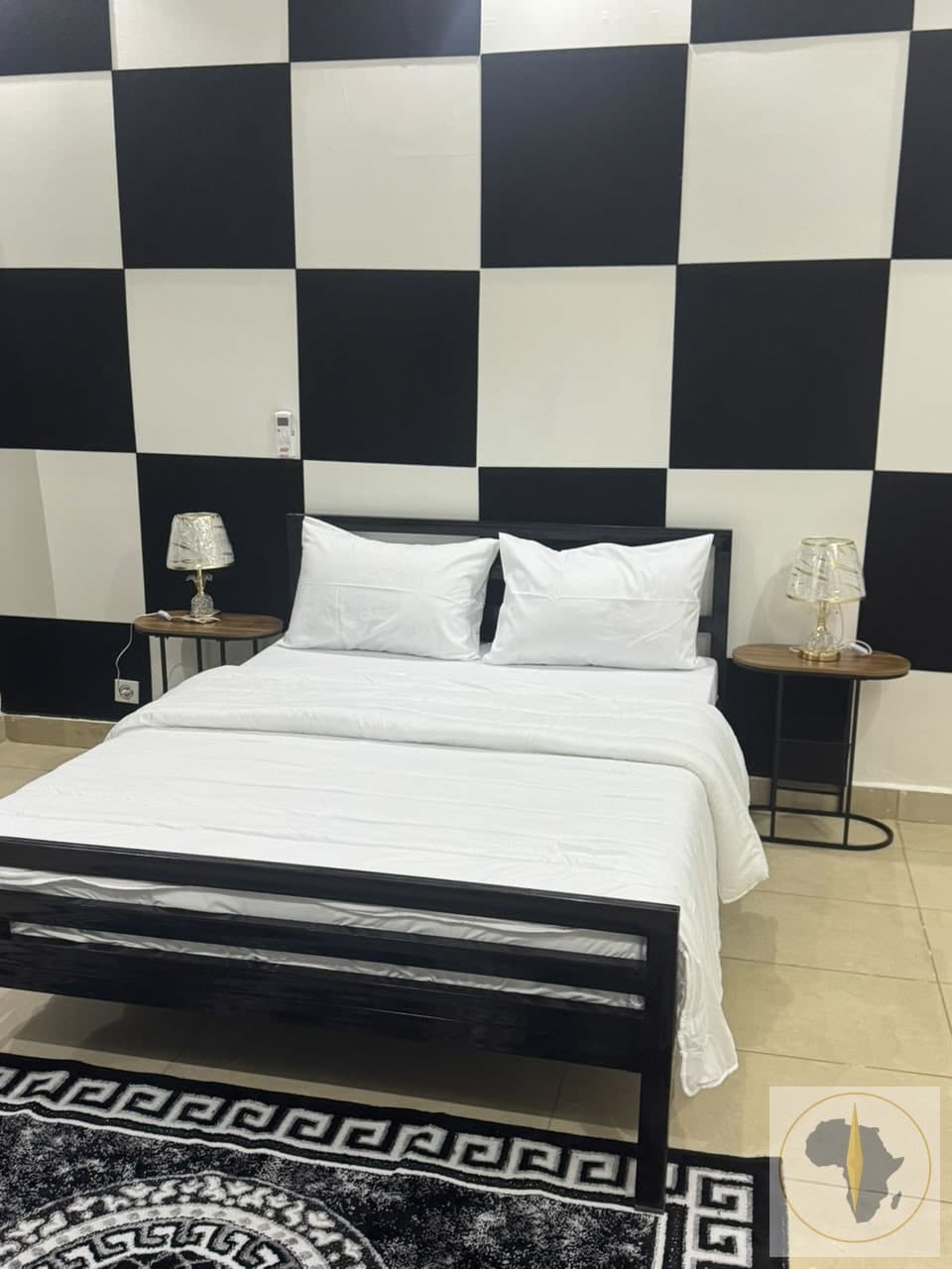 chambre climatisée avec un canapé et une salle de bain — Appartement en location saisonnière à Louga — OroSira Immo
